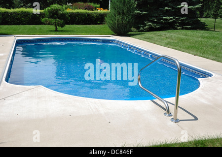 Piscine dans le jardin à la maison sur un jour d'été ensoleillé Banque D'Images