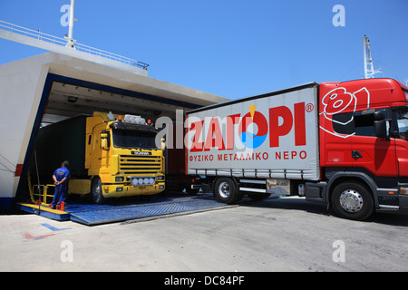 Camions de transport la sortie d'un ferry dans le port grec d'Igoumenitsa. ΖΑΓΟΡΙ (ZAGORI) est une compagnie grecque de l'eau en bouteille. Banque D'Images