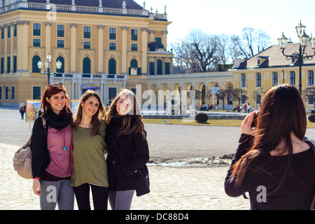 Tourisme trois adolescentes posant pour la photo devant le palais Schönbrunn à Vienne, Autriche Banque D'Images