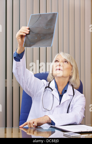 Doctor looking at x-ray image at desk in office Banque D'Images
