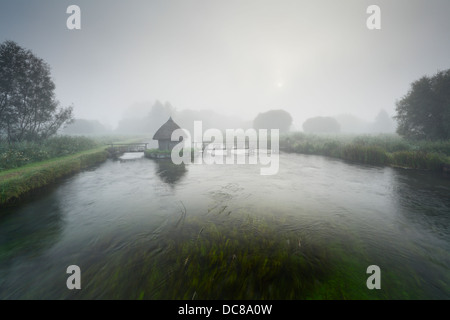 Cabane de pêcheur et les pièges de l'anguille de l'autre côté de la rivière Test sur l'Estate Leckford à Longstock. Le Hampshire. L'Angleterre. UK. Banque D'Images