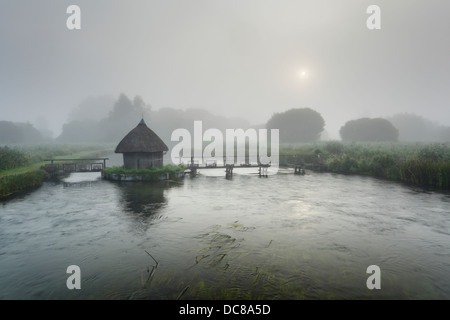 Cabane de pêcheur et les pièges de l'anguille de l'autre côté de la rivière Test sur l'Estate Leckford à Longstock. Le Hampshire. L'Angleterre. UK. Banque D'Images