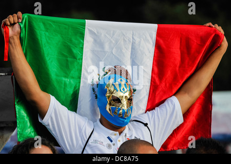 Un homme porte un masque de catcheur mexicain et nous tend un drapeau mexicain Banque D'Images