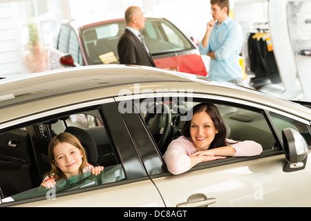 Smiling mother and daughter essayer voiture en concession Banque D'Images