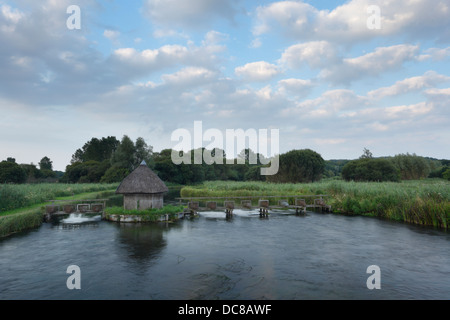 Pièges à anguilles et cabane de pêche sur la rivière Test, une partie du domaine près de Longstock Langford. Le Hampshire. L'Angleterre. UK. Banque D'Images