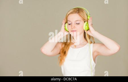 Portrait d'une adolescente blonde aux yeux clos d'écouter de la musique Banque D'Images