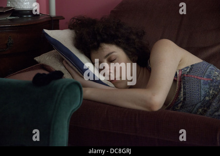 Jeune femme pan sur son canapé à la maison dans la ville de New York. Banque D'Images