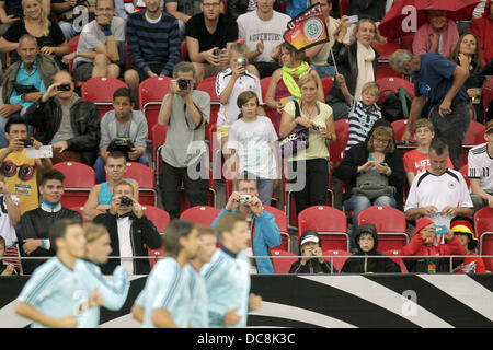 Mainz, Allemagne. Août 12, 2013. Les spectateurs de prendre des photos de joueurs de football nationale allemande qui passé entre eux au cours de la jog formation publique de l'équipe nationale de football allemande à la Coface Arena à Mainz, Allemagne, 12 août 2013. Photo : FREDRIK VON ERICHSEN/dpa/Alamy Live News Banque D'Images