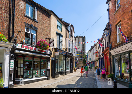 Boutiques dans la ville historique de Kirkgate, en direction de la cathédrale, Ripon, North Yorkshire, Angleterre, Royaume-Uni Banque D'Images