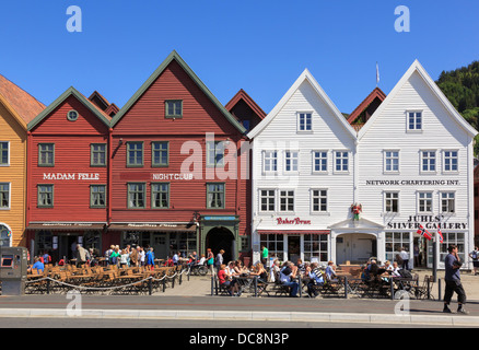 Les gens dans la rue en plein air restaurants par bâtiments en bois historique en été sur Bryggen, Bergen, Hordaland, Norvège, Scandinavie Banque D'Images