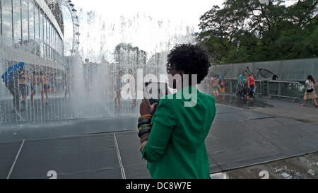 Femme avec l'ipad mini photographier dans l'eau fontaine en été à l'extérieur de Royal Festival Hall Southbank London England Banque D'Images