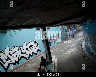 Les artistes travaillant sur mur dans Leake Street Graffiti Tunnel, Lambeth London England UK Banque D'Images