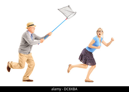 Portrait d'une jeune femme essayant de peur de fugueurs homme mûr avec butterfly net Banque D'Images