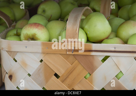 En bois d'un panier plein de produits frais, bio, de saison des pommes à vendre avec place pour le texte sur le fond Banque D'Images