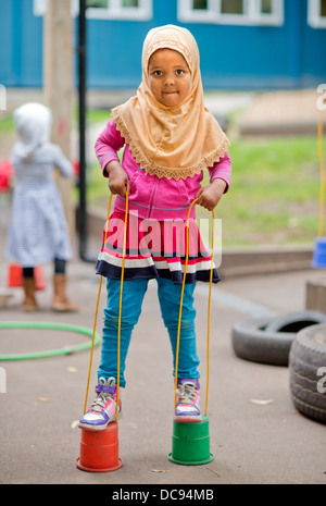 L'école maternelle Pauls et Children's Centre, Bristol UK - un Somalien fille jouant sur pilotis dans l'aire de jeux. Banque D'Images