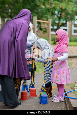 L'école maternelle Pauls et Children's Centre, Bristol UK - Les filles jouant sur pilotis dans l'aire de jeux. Banque D'Images