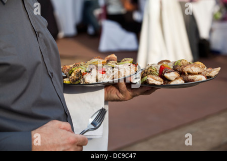 Waiter carrying plat avec de la nourriture Banque D'Images