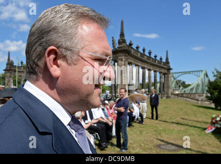 Berlin, Allemagne. Août 13, 2013. Le sénateur de l'intérieur de Berlin, Frank Henkel (avant) promenades à travers drapeaux allemands au pont de Glienick lors d'un événement organisé par le CDU pour marquer le 52e anniversaire de la construction du mur de Berlin en 1961. Photo : RALF HIRSCHBERGER /afp/Alamy Live News Banque D'Images