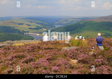 Les marcheurs se reposer sur le bord à l'égard Bamford Ladybower Reservoir, Derbyshire, Peak District National Park, Angleterre, Royaume-Uni. Banque D'Images