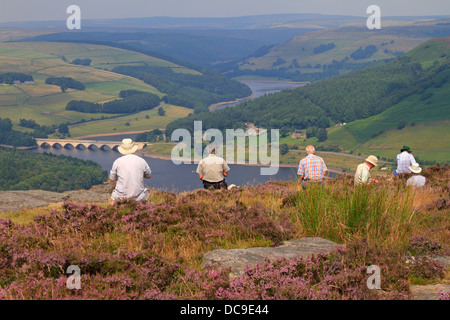 Les marcheurs se reposer sur le bord à l'égard Bamford Ladybower Reservoir, Derbyshire, Peak District National Park, Angleterre, Royaume-Uni. Banque D'Images