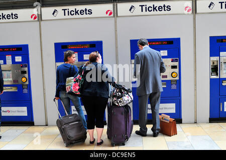 Les passagers essayant d'acheter des billets dans les distributeurs automatiques de billets, Paddington, London, UK Banque D'Images