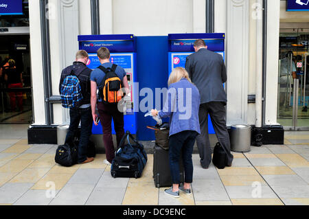 Les passagers ferroviaires l'achat de billets dans les distributeurs automatiques de billets, la gare de Paddington, Londres Banque D'Images