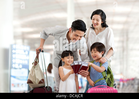 Heureux jeune famille avec les billets et les passeports à l'aéroport. Banque D'Images