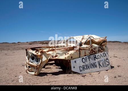 Vue d'un accident de voiture avec de nombreux trous de balle et un panneau "Off Road au volant tue" sur une route près de Brandberg ouest nord de Swakopmund en Skeleton Coast National Park en Namibie, 6 décembre 2010. Photo : Tom Schulze Banque D'Images