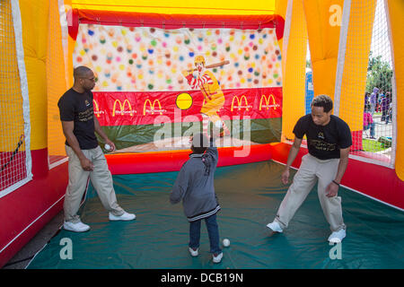 Detroit, Michigan, USA. Un garçon jette une balle dans un McDonald's stand lors d'un Festival Retour à l'école parrainée par une plus grande Grace Temple, une église pentecôtiste 6 000 membres. Le festival annuel des jeux, de la nourriture, des dépistages, coupes de cheveux, et les dons de fournitures scolaires. Crédit : Jim West/Alamy Live News Banque D'Images