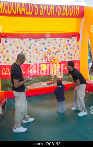 Detroit, Michigan, USA. Un garçon jette une balle dans un McDonald's stand lors d'un Festival Retour à l'école parrainée par une plus grande Grace Temple, une église pentecôtiste 6 000 membres. Le festival annuel des jeux, de la nourriture, des dépistages, coupes de cheveux, et les dons de fournitures scolaires. Crédit : Jim West/Alamy Live News Banque D'Images