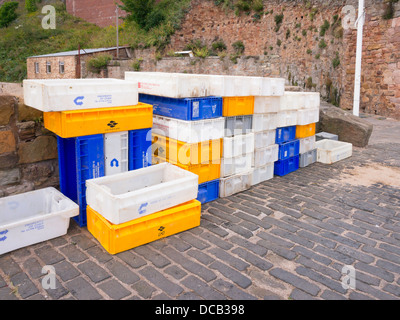 Les boîtes de poisson vide prêt à l'emploi sur le mur du port dans le village de Crail à Fife en Écosse Banque D'Images