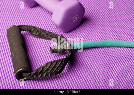 L'équipement d'exercice sur un tapis de yoga violet Banque D'Images