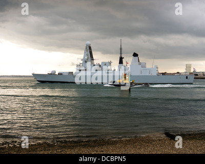 Le type 45 class destroyer HMS Daring, D32, laissant le port de Portsmouth accompagné par le remorqueur indépendant SD Banque D'Images