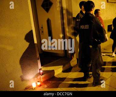 Les agents de police se tenir en face de l'entrée d'un immeuble à appartements à Essen, Allemagne, 14 août 2013. A 51 ans, sa fille aurait été abattu mortellement et grièvement blessé sa femme. Le coupable est en fuite. Photo : MARIUS BECKER Banque D'Images