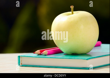 Outils pour l'école avec apple placé près sur fond vert Banque D'Images