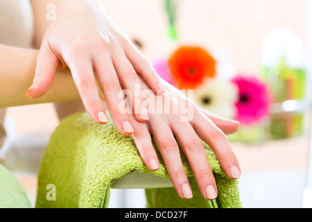 Femme dans un salon de manucure recevant une manucure par une esthéticienne, symbole photo avec les mains Banque D'Images