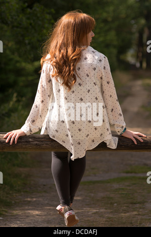 Une image verticale d'une jeune femme aux longs cheveux rouges avec son dos à l'appareil photo Banque D'Images