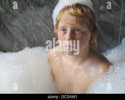 Boy in bubble bath Banque D'Images