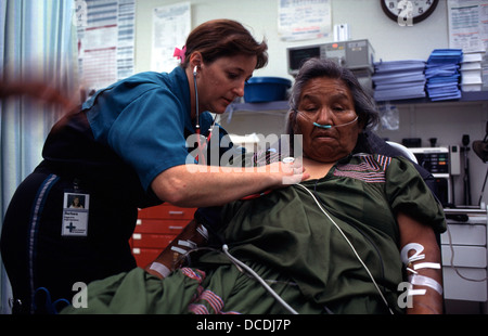 Une infirmière de vol examine une dame de la réserve amérindienne à San Carlos, en Arizona, où elle est à prendre à partir de la piste d'Arizona rurales par twin-hélice avion motorisé, d'une ambulance aérienne, à l'hôpital pour traitement. Le San Carlos Apache Indian Reservation, dans le sud-est de l'Arizona, Etats-Unis, a été créée en 1872 comme une réserve pour la tribu apache Chiricahua. Il a été mentionné par certains en tant que "Hell's quarante acres,' à cause d'une myriade de santé lamentable et les conditions environnementales. (Plus de légende dans la description) Banque D'Images