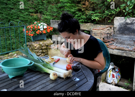 Jeune femme 20s la préparation de repas au gîte de séjour dans la région de Lot France Banque D'Images