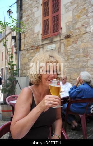 Femme buvant un verre de bière blonde bière Stella Artois à l'extérieur d'un bar à Puy L'Evêque dans le Lot Région ou département France Banque D'Images