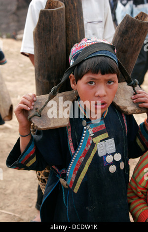 Jeune fille Akha transportant une charge lourde dans un village tribal près de Phongsali, Laos Banque D'Images