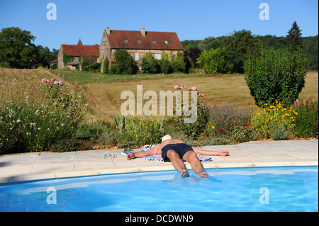 Détente Homme à côté d'une piscine d''un gîte de séjour à Frayssinet-Le-gelat dans le Lot Région ou département France Banque D'Images