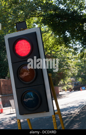 Feux de circulation temporaires à des travaux montrant un feu rouge. Banque D'Images