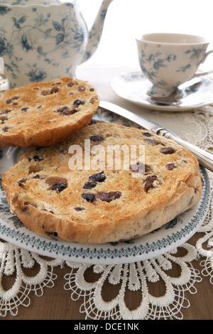 Un Teacakes grillé britannique traditionnel gâteau de raisins, raisins secs et les épices dans un petit pain. Souvent consommés comme collation avec thé de l'après-midi. Banque D'Images