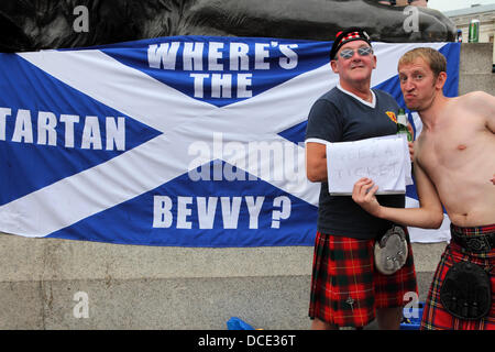 Londres, Royaume-Uni. 14Th Aug 2013. 'Où est la demande d'un travelo hallucinant ?' flag derrière les passionés du football écossais à Trafalgar Square à Londres, en Angleterre. Un homme est titulaire d'un 'ticket' geeza signe. Credit : whyeyephotography.com/Alamy Live News Banque D'Images