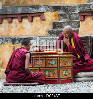 La Chine, Xizang (Tibet, Lhassa, deux moines assis ensemble à l'intérieur des murs de monastère de Séra Banque D'Images