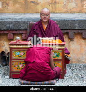 Deux moines assis ensemble à l'intérieur des murs de monastère de Séra, Lhassa, Tibet, Xizang, Chine Banque D'Images