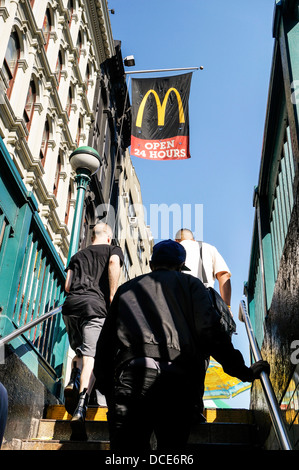 Les gens de quitter la station de métro Canal street sont accueillis par une bannière pour voler à proximité d'un restaurant Mcdonald's, comme ils monter les escaliers Banque D'Images