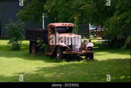 1934 International Truck se trouve abandonné par une grange. Banque D'Images